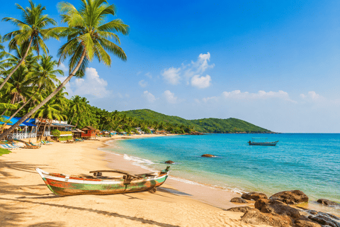 Goa beach with palm trees and traditional fishing boat